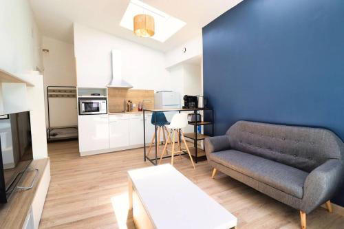 un salon avec un canapé et une cuisine dans l'établissement Bright and fully equipped studio, à Arras