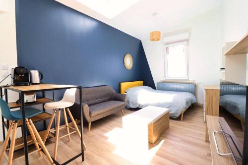 Cette petite chambre comprend un lit et un mur bleu. dans l'établissement Bright and fully equipped studio, à Arras