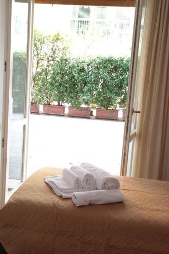 a pair of towels sitting on a bed in front of a window at Guest House Manara in Reggio Emilia