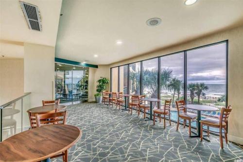 a restaurant with tables and chairs and a view of the ocean at WINTER RATES! Captivating Coastal Charm - Oceanview Suite! PG 504 in Myrtle Beach