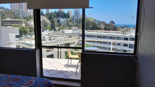 a room with a window with a view of a building at Hostal SAKAR Reñaca Beach in Viña del Mar