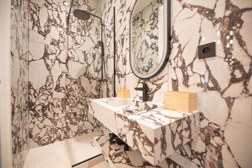 une salle de bain avec un lavabo et un miroir dans l'établissement Lovely & Romantic Suite near Bastille, à Paris