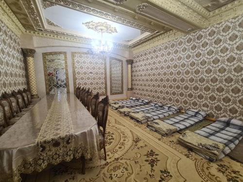 a dining room with a long table and chairs at Saidjanov Hostel in Bukhara