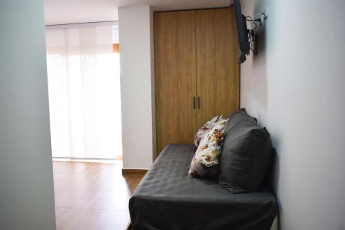 a black couch with a pillow on it in a room at Hotel Gran Plaza San Agustin in San Agustín