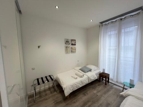 une chambre blanche avec un lit et une fenêtre dans l'établissement Residence Sao Jorge, à Cannes