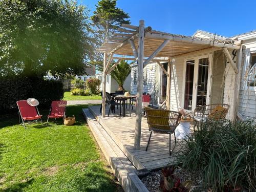 a wooden deck with chairs and a table in a yard at Camping de la côte des légendes in Brignogan-Plages