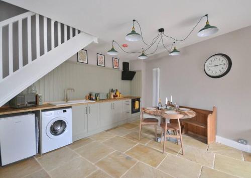 a kitchen with a table and a sink and a clock at St Nicholas Corner - A New Unique Town Centre Home in King's Lynn
