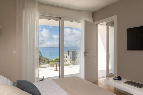 a bedroom with a bed and a view of the ocean at Villa Milagros in Kožino