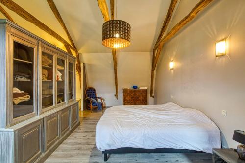 une chambre avec un lit et un lustre dans l'établissement gite de bervic avec piscine, à Sainte-Croix