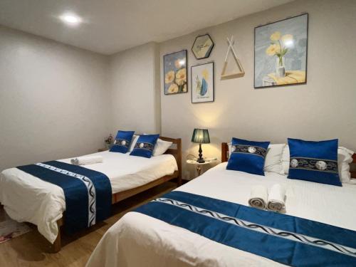 a bedroom with two beds with blue and white sheets at Newly Riverbank suites 408 in Kuching