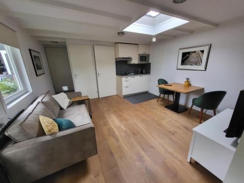 a living room with a couch and a table at Spacious private guest house in Hilversum