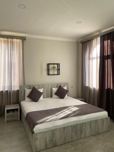 a bedroom with a large bed with pillows at Hotel Menua in Yerevan