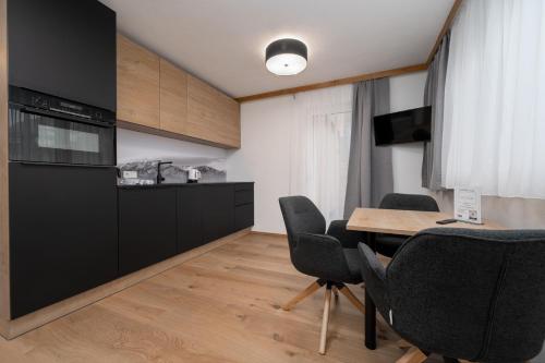 a kitchen and dining room with a table and chairs at A CASA Türkis in Sölden