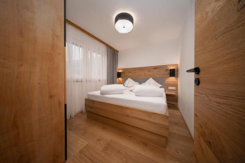 a bedroom with a bed with white sheets and pillows at A CASA Türkis in Sölden