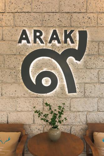 a sign that saysarc on a brick wall with a table at Arak 9 Villa in the Old Town in Chiang Mai