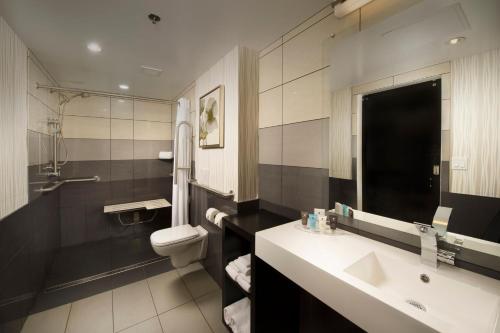a bathroom with a sink and a toilet at Skybridge Seattle Airport Hotel in Seattle
