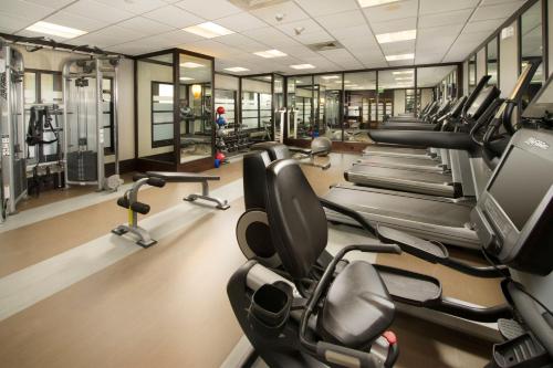 a gym with a row of treadmills and ellipticals at Skybridge Seattle Airport Hotel in Seattle