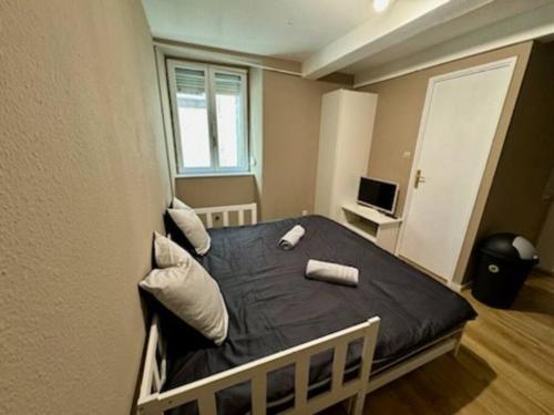 - une chambre avec un lit doté d'une couette noire et d'une fenêtre dans l'établissement Appartement proche place de la réunion au calme, à Mulhouse