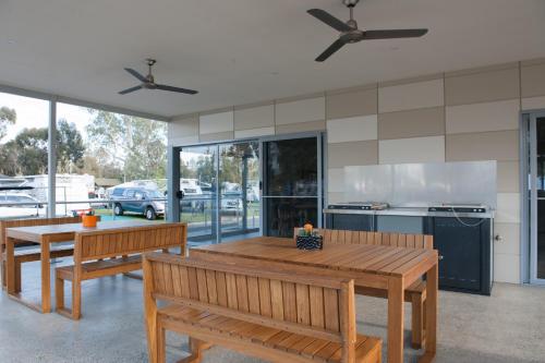 una cocina con 2 bancos de madera y una mesa en NRMA Echuca Holiday Park, en Echuca