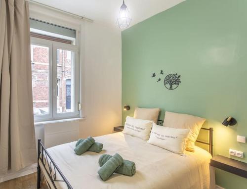 een slaapkamer met een bed met twee kussens erop bij L'Hortillon Amiens 4 pers 8min Centre ville & Gare in Amiens