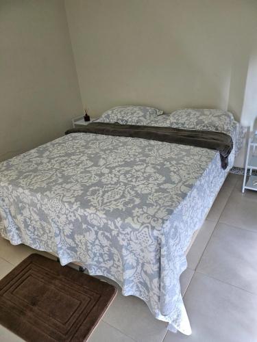two beds in a small room with a bedspread and a rug at Villa das Águas o Paraiso in Praia do Saco