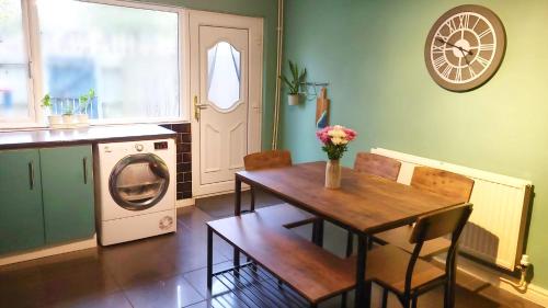 a kitchen with a table and a washing machine at 3 Bed House Close to Town & Cricket Ground in Nottingham