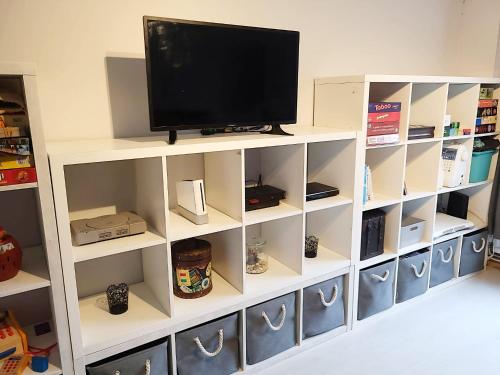 a white book shelf with a television on it at 3 Bed House Close to Town & Cricket Ground in Nottingham