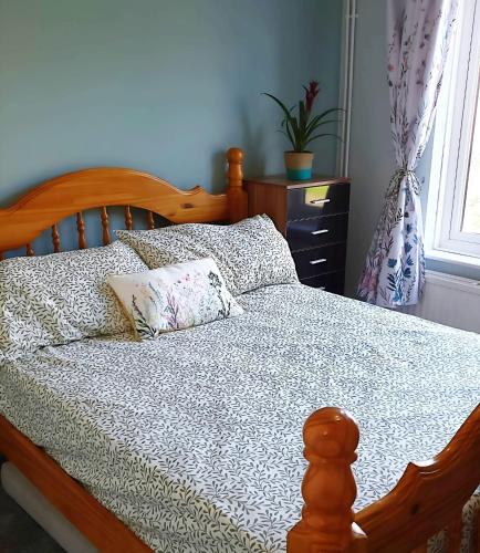 a bedroom with a wooden bed with two pillows at 3 Bed House Close to Town & Cricket Ground in Nottingham
