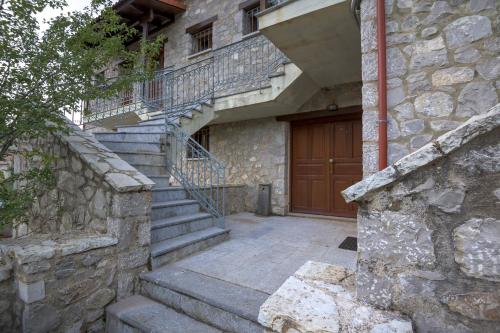 a stone building with stairs and a wooden door at Cosy Loft in Kalyvia Arachovas in Kalívia