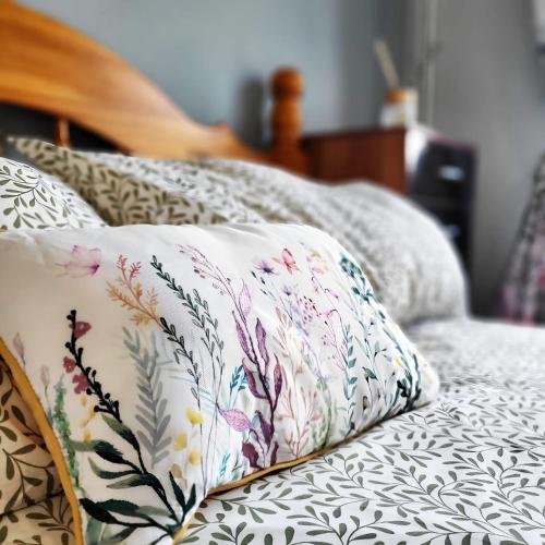 a pillow sitting on top of a bed at 3 Bed House Close to Town & Cricket Ground in Nottingham