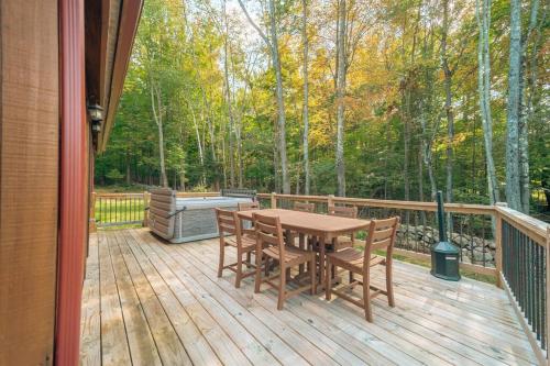 a wooden deck with a wooden table and chairs at ADK Whiteface Chalet with Hot Tub, Dog Friendly! in Wilmington