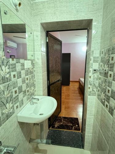 a bathroom with a sink and a mirror at Angelina guest house, Anjuna Beach Road in Anjuna