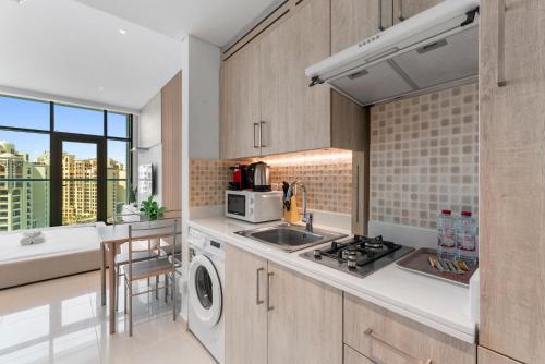 a kitchen with a sink and a stove at Seven Palm Hotel with West beach access in Dubai