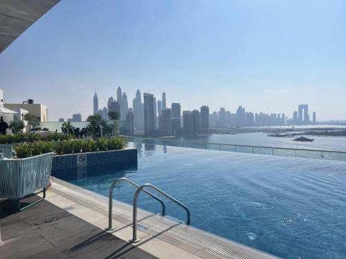 a swimming pool with a city skyline in the background at Seven Palm Hotel with West beach access in Dubai