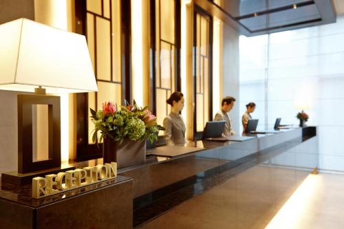 a group of people working in an office lobby at LOTTE City Hotel Myeongdong in Seoul