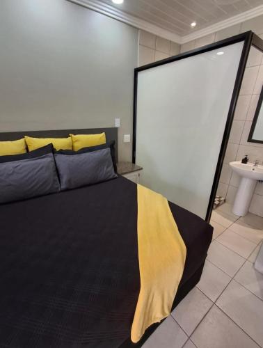 a bedroom with a bed with a yellow blanket on it at 9 Levubu Cottages in Polokwane