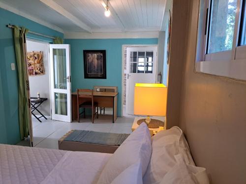une chambre avec un lit, une table et un bureau dans l'établissement The Willow Cottage, au Cap