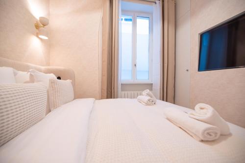 une chambre avec un lit blanc avec des serviettes dessus dans l'établissement Apartment in montmartre, à Paris