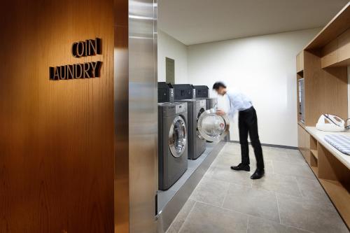a man standing in front of a washing machine at LOTTE City Hotel Myeongdong in Seoul