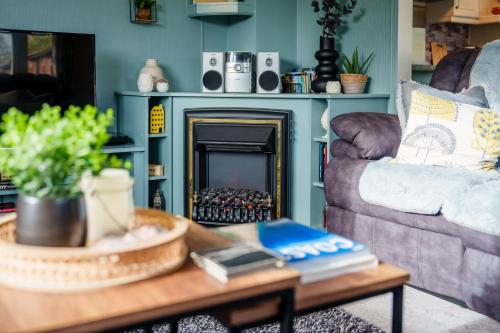 a living room with a couch and a coffee table with a fireplace at Peaceful 3-Bed Lodge ! Ideal for Families! in Warton