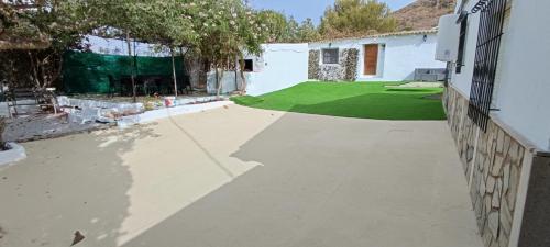 a driveway in front of a house with a green yard at La Jordana 39, Calblanque in Las Barracas