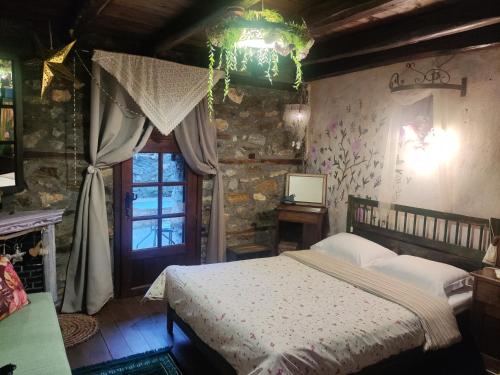 a bedroom with a bed in a room with a window at Feggaropetra Inn Magic Mountain House in Palaios Panteleimonas
