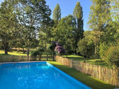 une piscine dans une cour clôturée dans l'établissement Le Cottage limousin, gîte de charme en bord de Vienne, à Saint-Brice-sur-Vienne