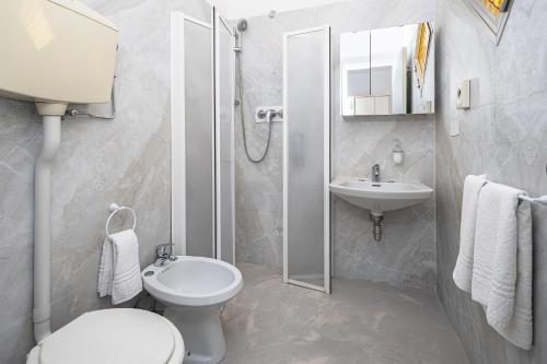 łazienka z toaletą, umywalką i prysznicem w obiekcie Hotel Gioiello w Cesenatico