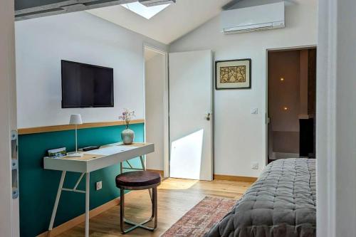 a bedroom with a desk and a bed and a tv at Le Cottage Limousin - gîte de charme en bord de Vienne, Limoges - airport in Saint-Brice-sur-Vienne
