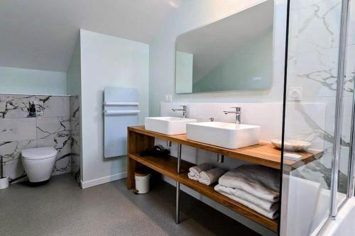 une salle de bain avec deux lavabos et une douche en verre dans l'établissement Le Cottage limousin, gîte de charme en bord de Vienne, à Saint-Brice-sur-Vienne
