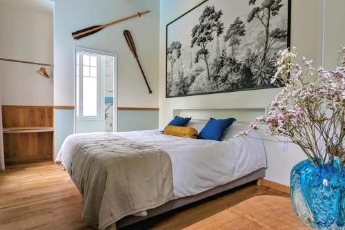 - une chambre avec un lit et un vase avec des fleurs dans l'établissement Le Cottage limousin, gîte de charme en bord de Vienne, à Saint-Brice-sur-Vienne