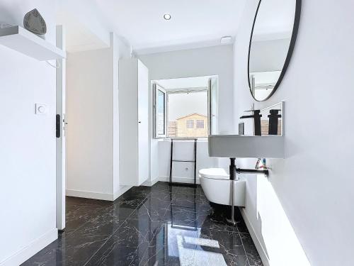 une salle de bain avec toilettes et miroir dans l'établissement Appartement cosy & moderne T2 avec jardin parking, à Brest