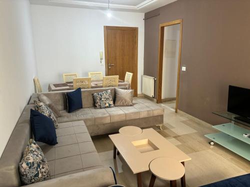 a living room with a couch and a table at Appart Meublé Cité ElWahat in El Aouina