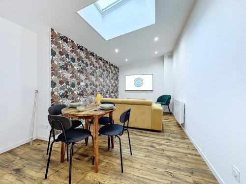 un salon avec une table, des chaises et un canapé dans l'établissement Appartement cosy & moderne T2 avec jardin parking, à Brest